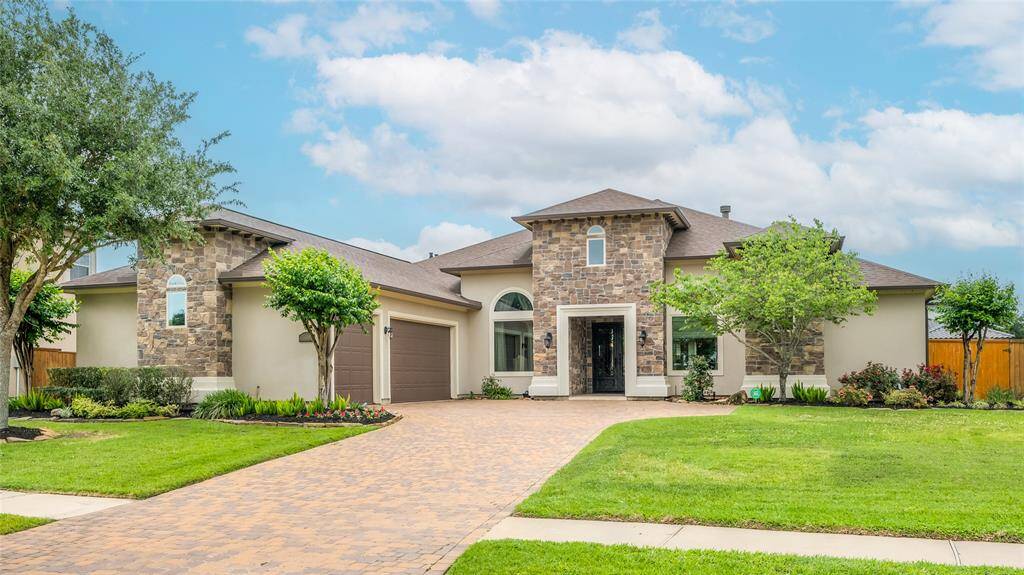 Natural stone and stucco enhance the elevation and the timeless beauty of paving stones capture Old World ambiance.