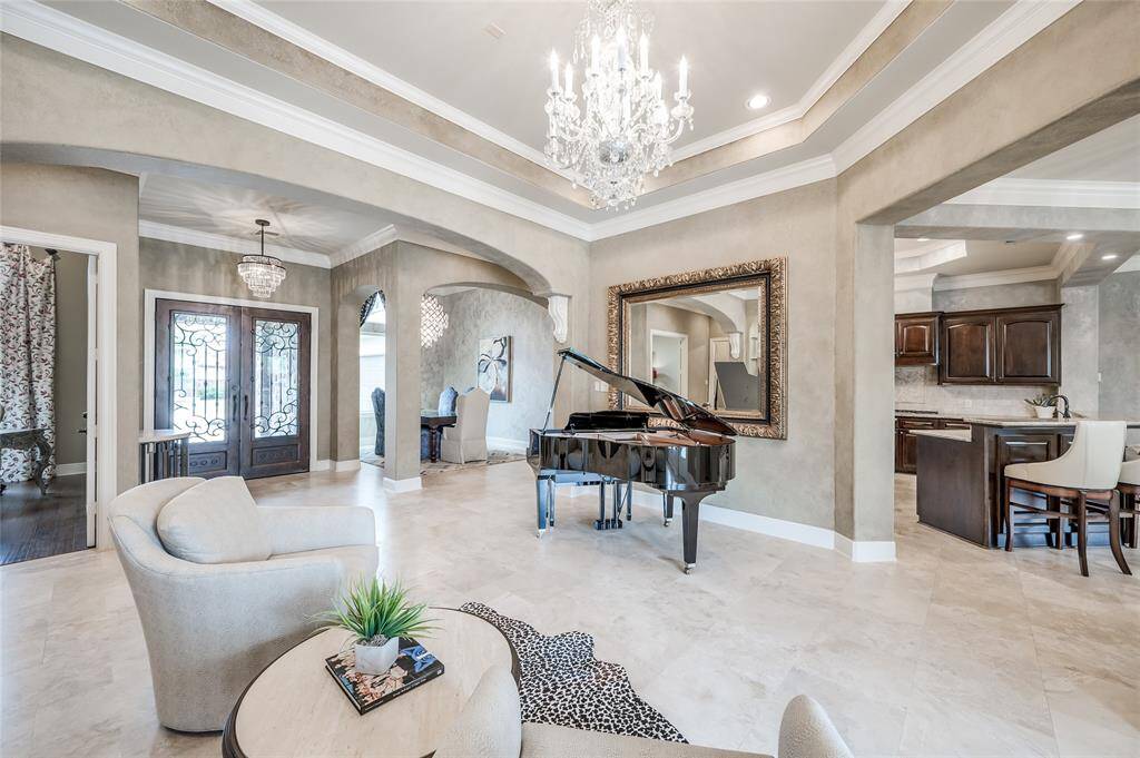 Beautiful double iron doors lend to the custom design of the home, creating the perfect first impression. Spectacular ceiling details and architectural arches evoke Old World charm and elevate the aesthetics of the home.