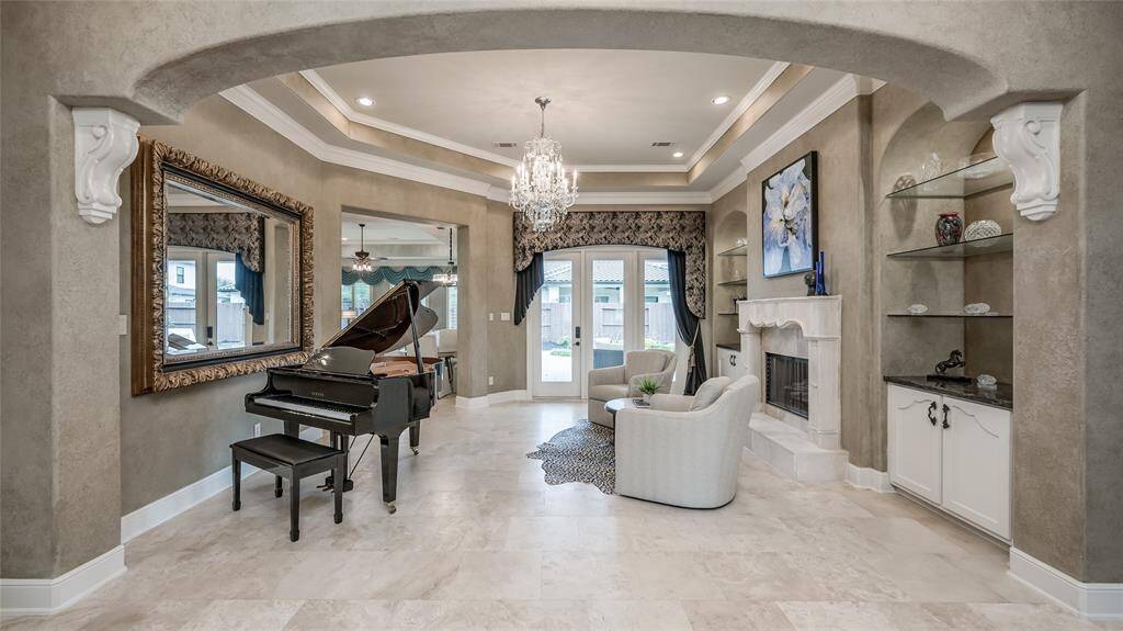 Natural stone travertine flooring seamlessly flows throughout the home and stunning windows illuminate the space with light from every angle. The home abounds with impeccable design and luxurious finishes.