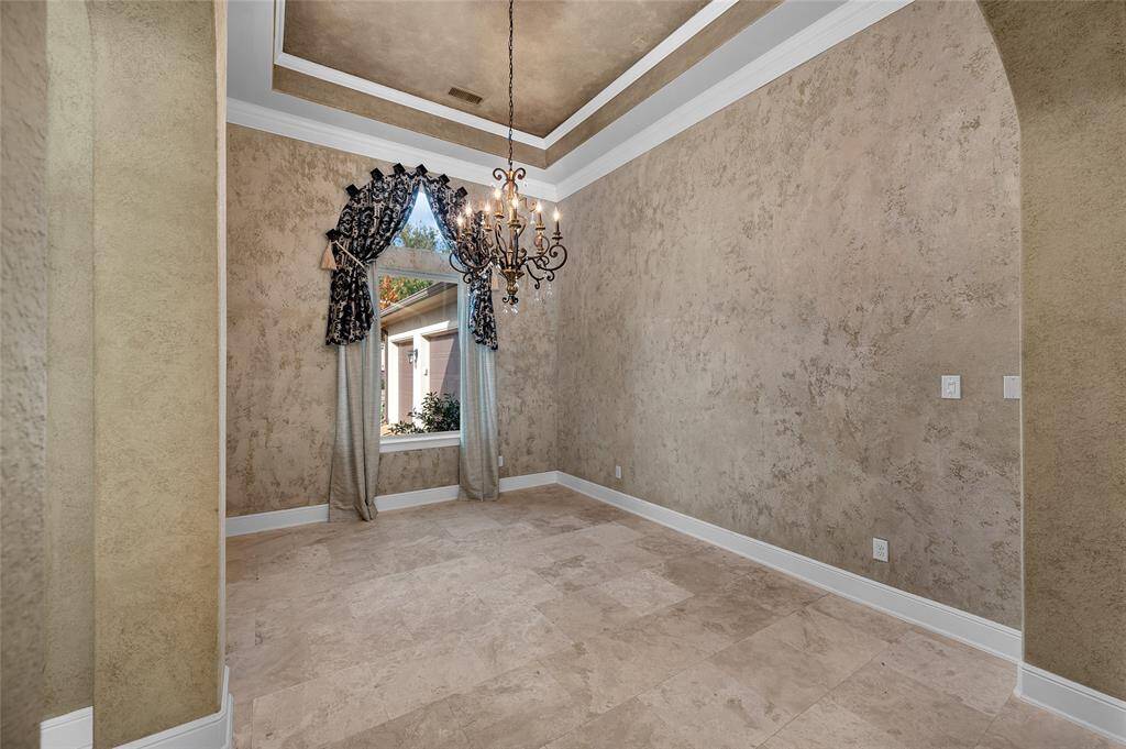Impressive and intimate, the dining room offers 14 ft tray ceilings and soft Venetian finish walls with custom details.