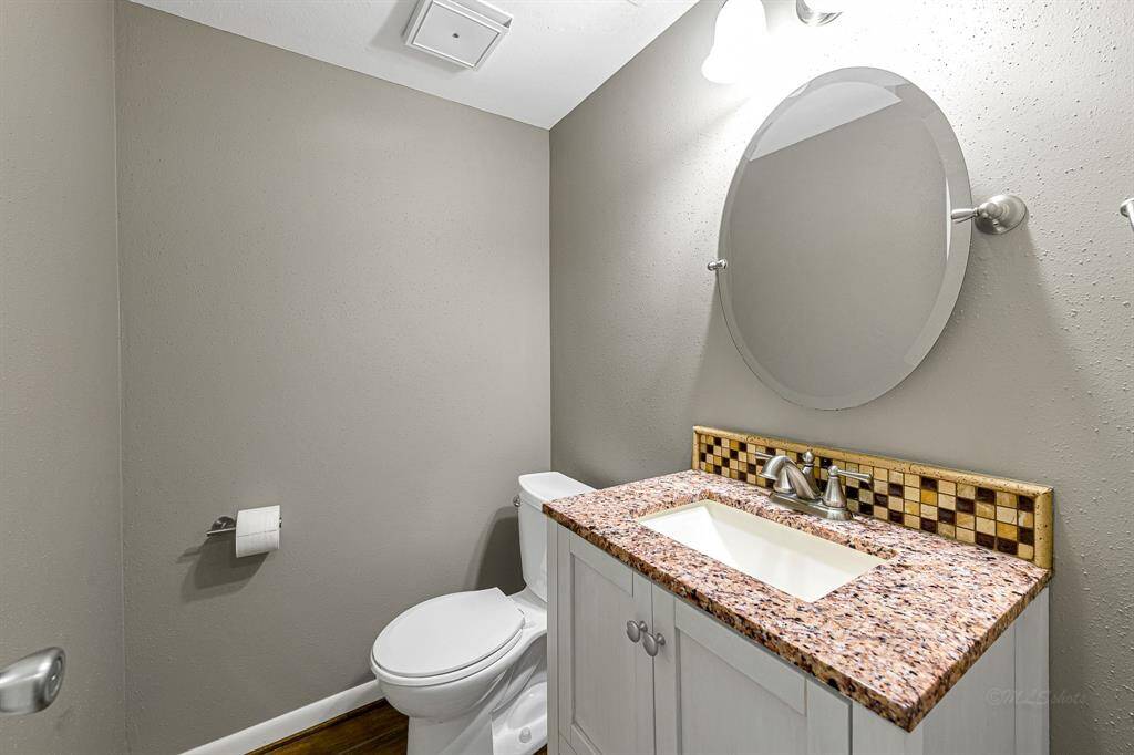 Half bath with granite countertop & decorative back splash