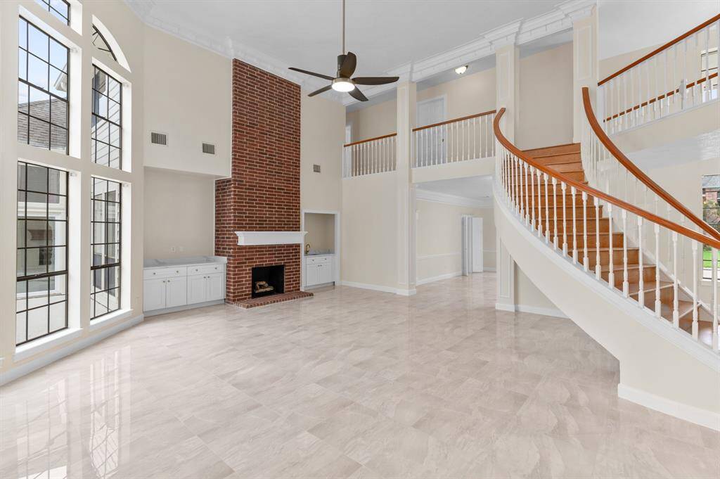 Curved staircase and soaring ceilings upon entrance with custom crown moldings and high-end finishes