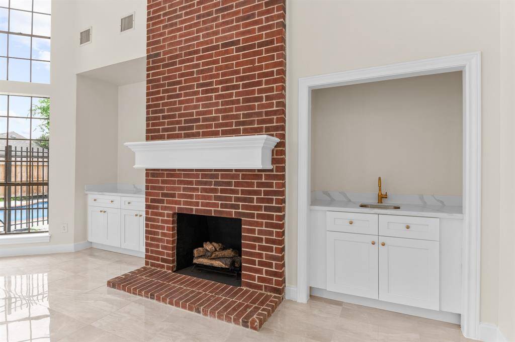 1st expansive Living room (1st floor) illuminated by natural light and adorned with brand-new light fixtures and a soaring fireplace