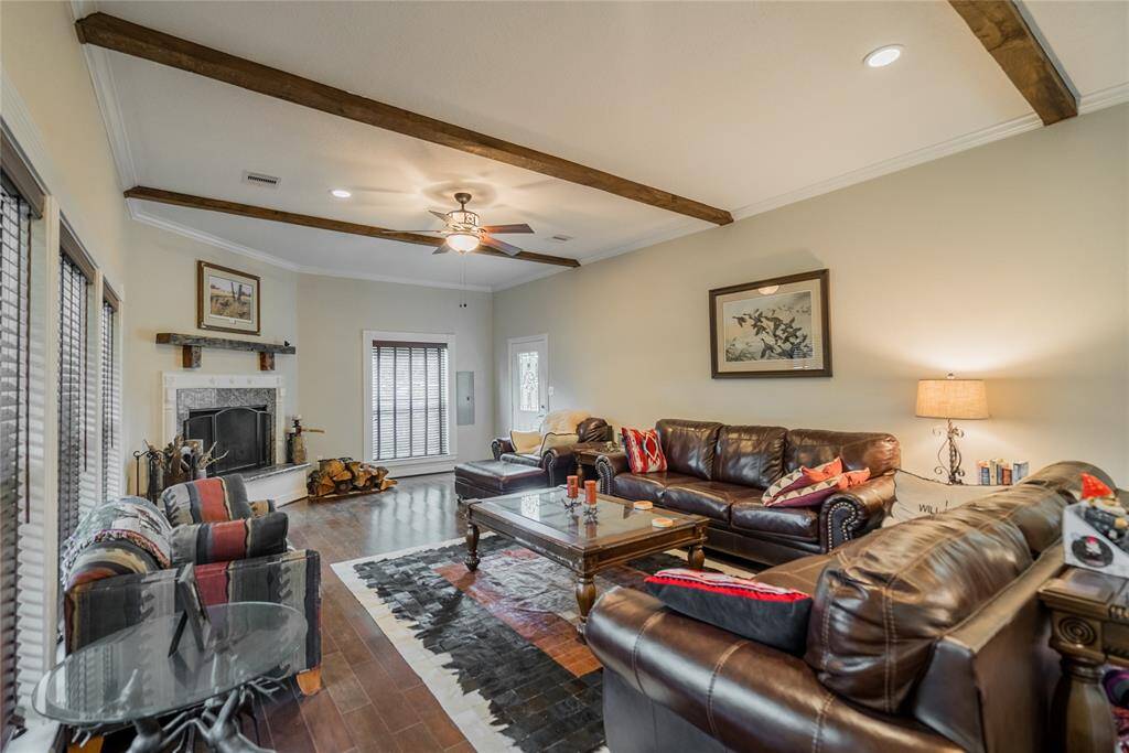 Beautiful Cherry wood floors, Ceiling beams are 6" X 6" Red Oak, Gorgeous over sized wood burning fireplace w/a very special old mantle hanging above the fireplace, Recessed lighting, Ceiling fans, Crown molding,  very thick glass windows, and Blinds on the windows round out this beautiful living room with lots of light and views of the Ranch.