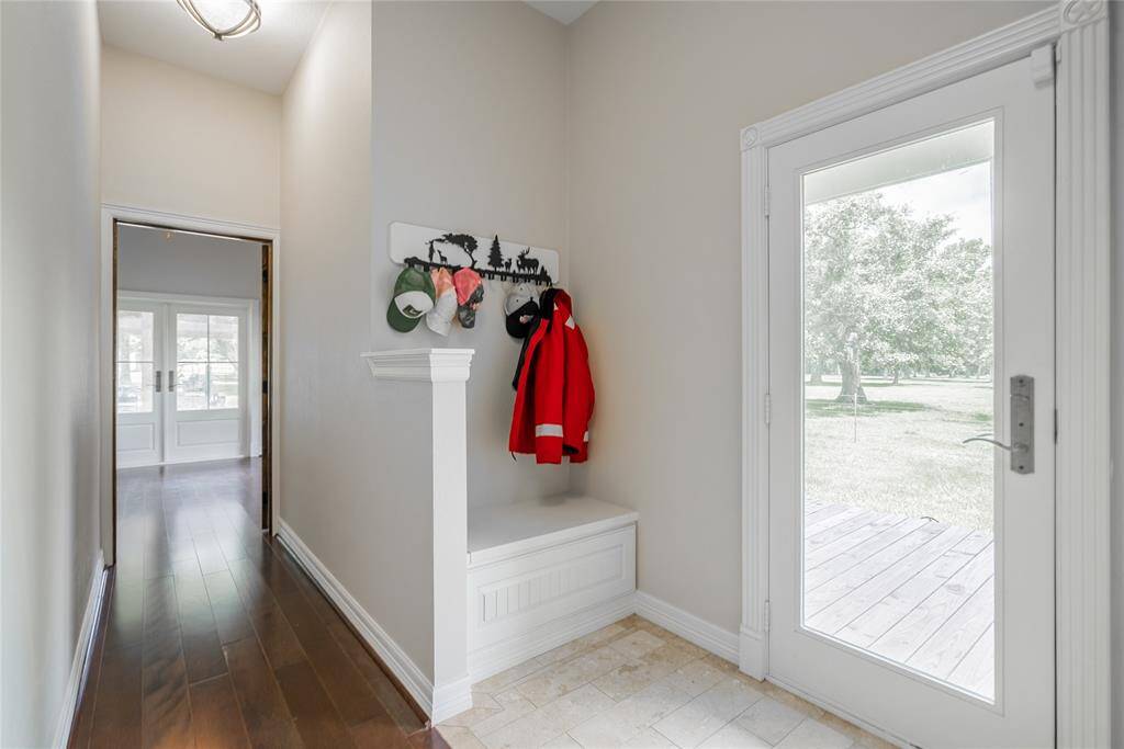 This is a mud room area with built in storage under the built in seat. Travertine on the floor in this area as well, and, of course, a door leading out to the porch.