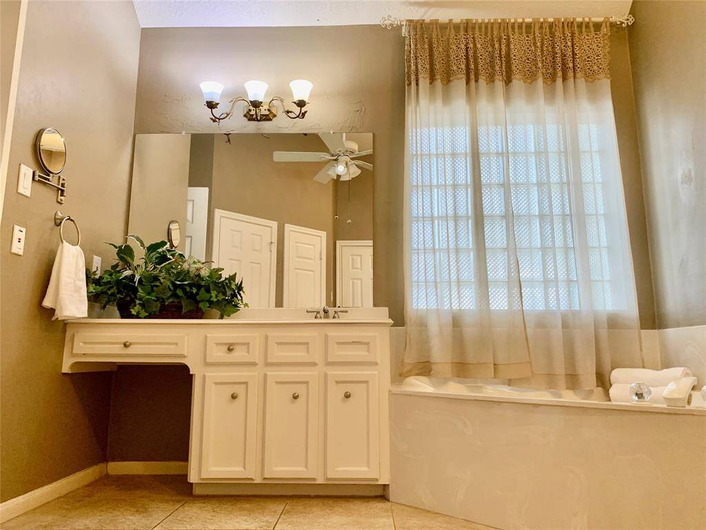 PRIMARY BATH WITH SOARING CEILINGS, VANITY AREA, AND CORNER TUB