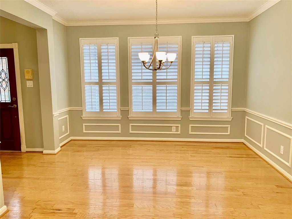 FORMAL DINING ROOM WITH CROWN AND PICTURE FRAME MOLDING. IT HAS CHAIR RAILING AND PLANTATION SHUTTERS.