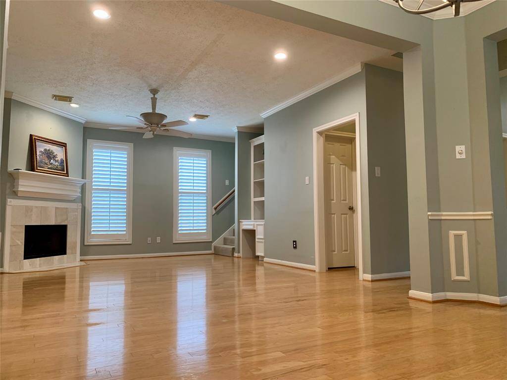 FAMILY ROOM WITH BUILT-IN DESK AND BOOK SHELVES, CORNER GAS LOG FIREPLACE, PLANTATION SHUTTERS, AND BEAUTIFUL HARDWOODS