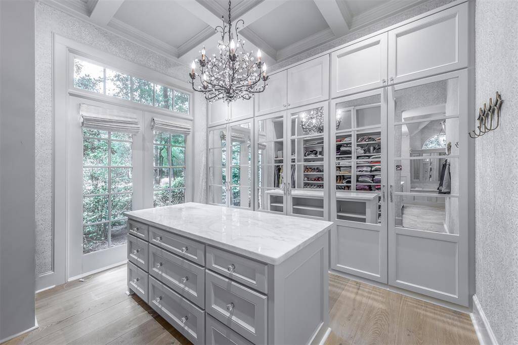 The biggest custom closet is incredibly functional and complete with hidden clothing departments, calaccatta quartz topped dresser and show & accessory storage. It is a truly dream!