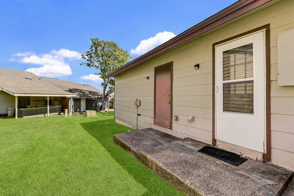 Convenient utility room access with back door and additional storage closet.