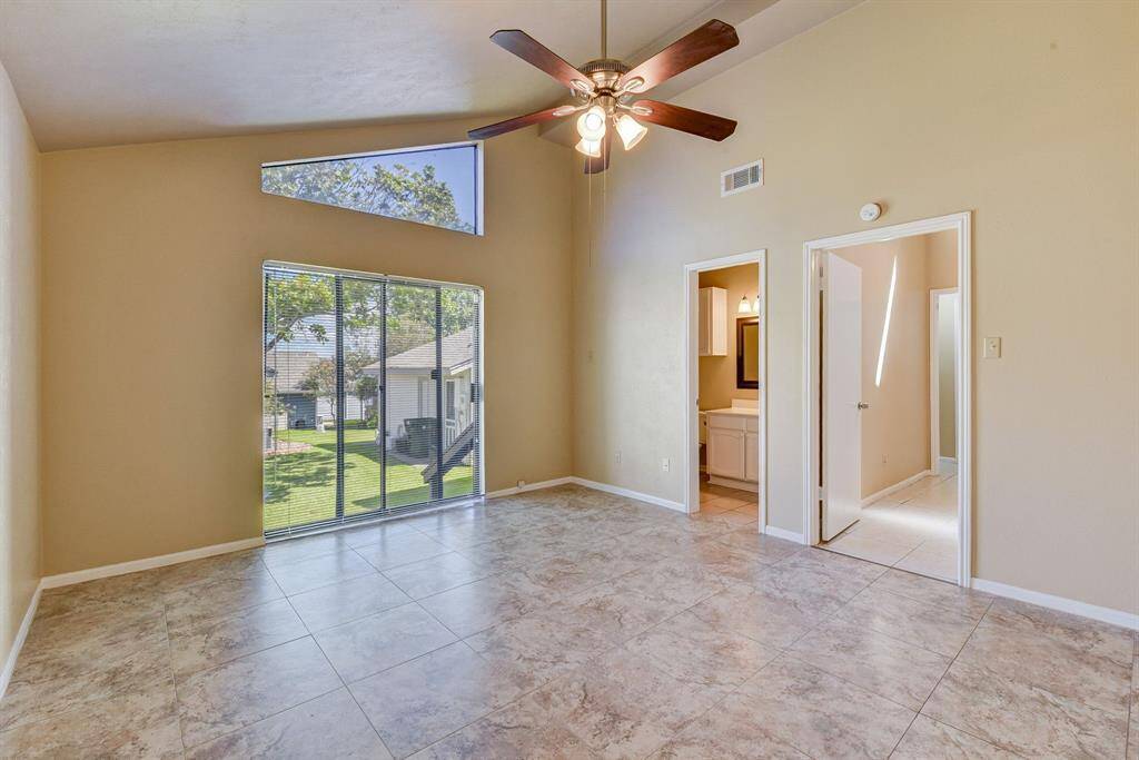 Luxurious primary bedroom featuring high ceilings and abundant natural light.