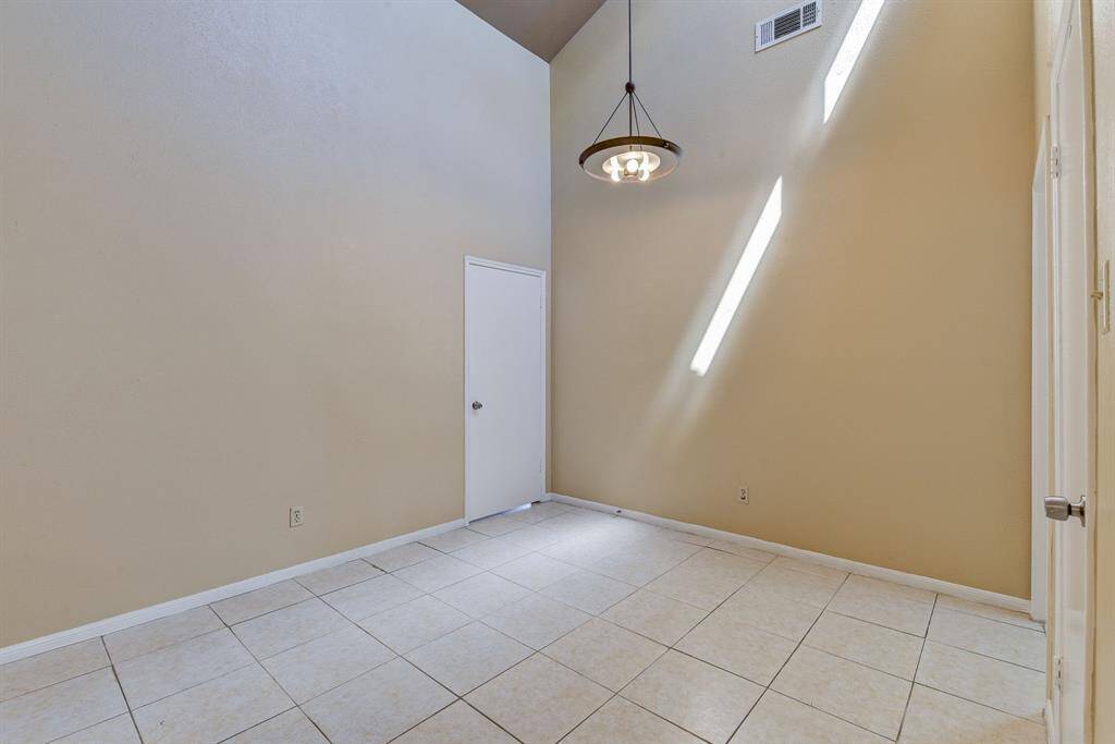 Bright and inviting dining area with high ceilings and tile flooring, perfect for gatherings and everyday meals.