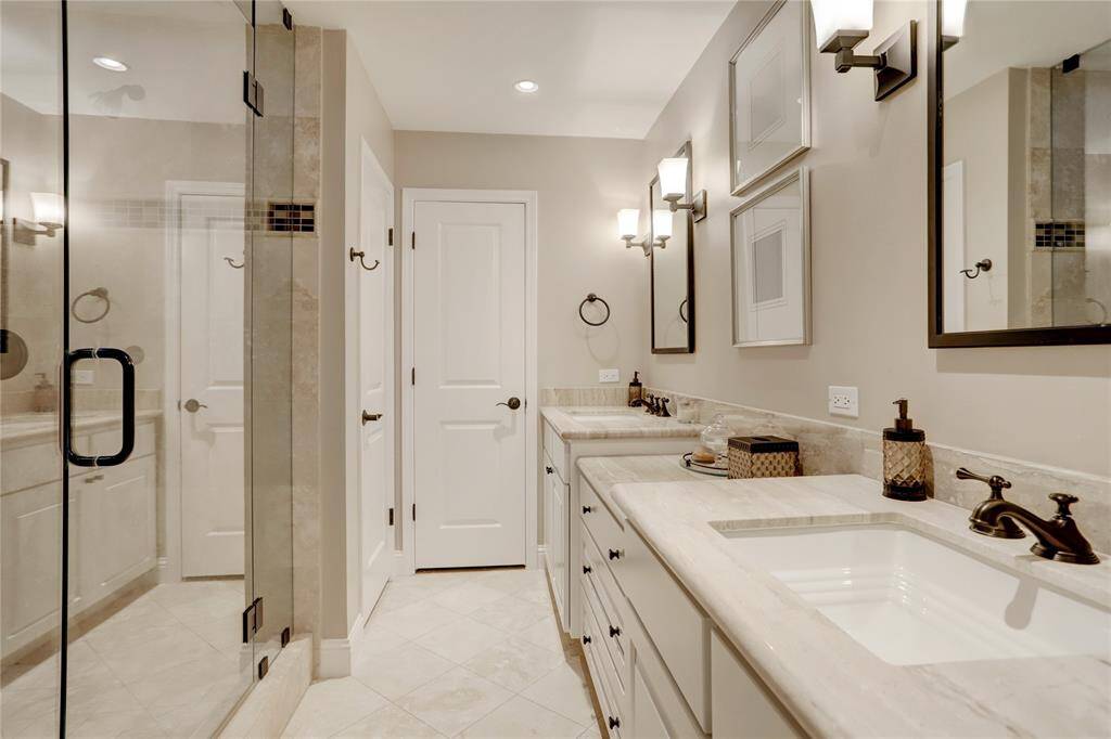 The first-floor primary bathroom features beautiful marble, two closets, & an enormous shower filled with natural light from the striking skylight.