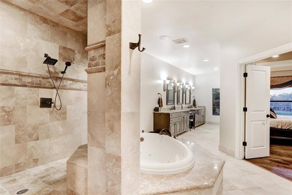 Spacious spa bathroom features two enormous closets and a secondary laundry station
