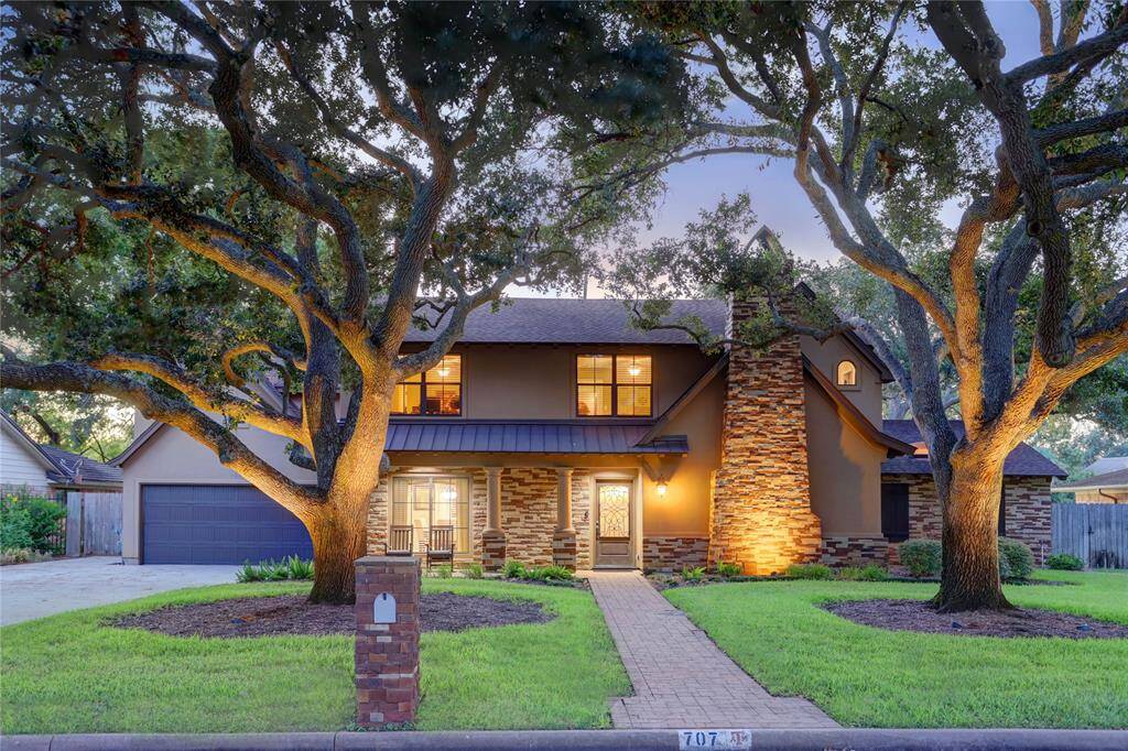 The charming European-style home is nesteled among gorgeous trees in front and back.