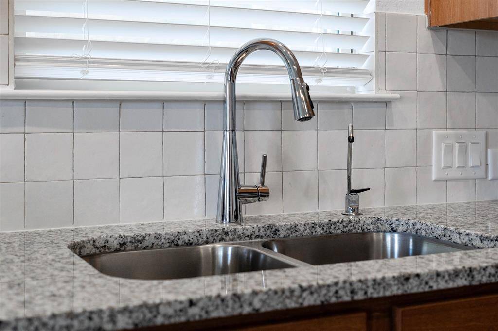 Featured here is the Moen Sleek Kitchen Faucet placed here with the undermount kitchen sink. This gorgeous backsplash is Daltile Zellige tile.
