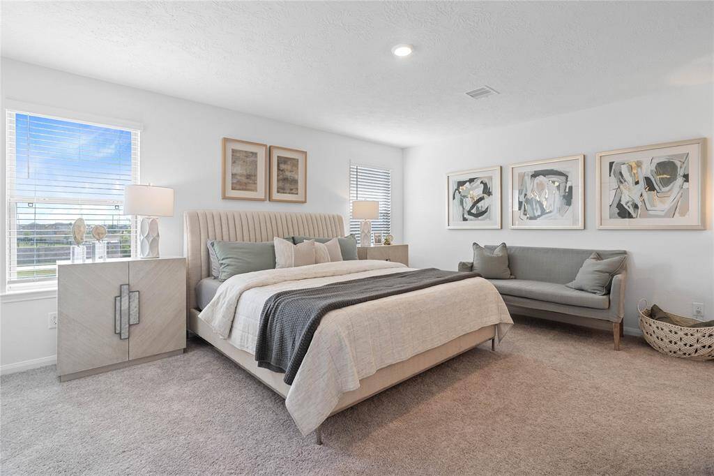 Come and unwind after a long day in this magnificent primary suite! This spacious room features plush carpet, warm paint, high ceilings, lighting, and large windows with privacy blinds.