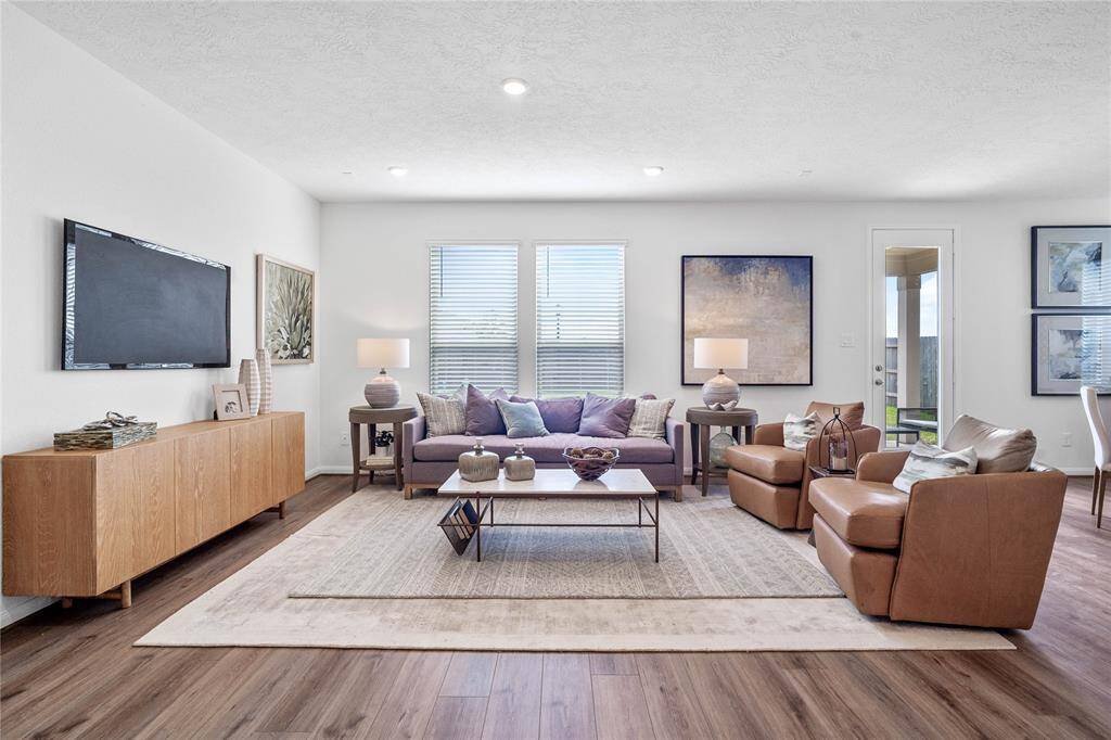 Gather the family and guests together in your lovely family room! Featuring high ceilings, recessed lighting, custom paint, gorgeous vinyl plank floors, and large windows that provide plenty of natural lighting throughout the day.