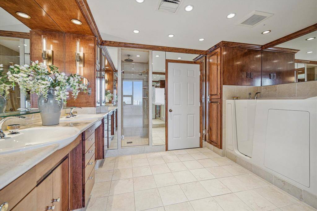 Generous, polished primary bath with separate shower, walk-in accessible bath tub, and private water closet with Toto commode and bidet.