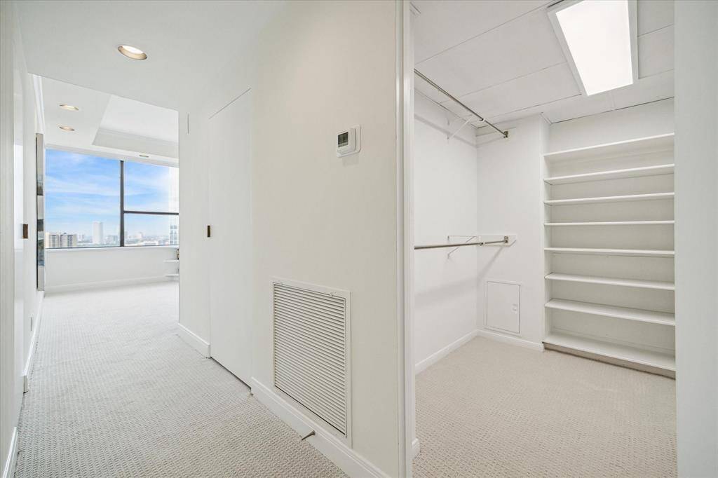The primary suite features two walk-in closets with brass door pulls, plus additional shelving closets.