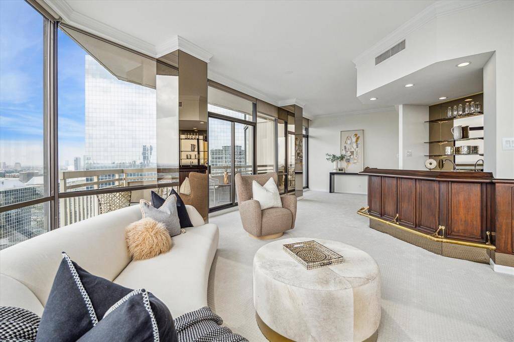 Glancing back at the other side of the L-shaped living area. Bronze-mirrored pillars enhance the views and blend right into the windows. Staging shown no longer in residence.