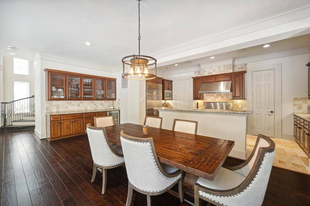 Adjacent to the kitchen lies a splendid butler's pantry, featuring a granite countertop, a wine refrigerator, and glass-fronted cabinets.
