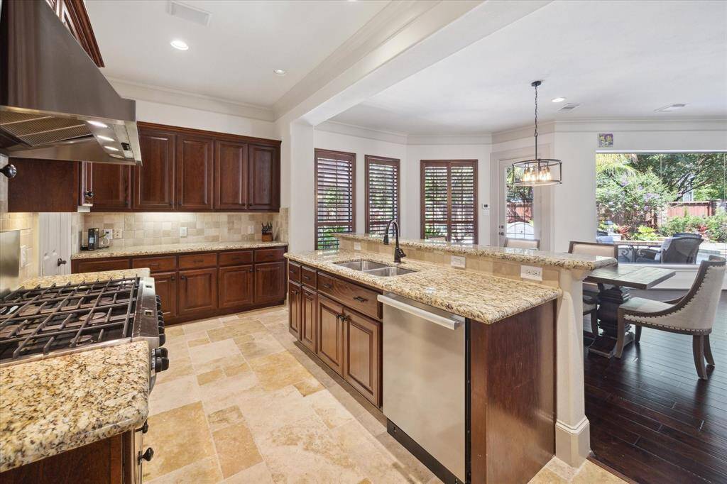 The kitchen boasts elegant granite countertops, travertine flooring, double ovens, an 8-burner gas range, a Sub-Zero refrigerator/freezer combination, and extensive cabinetry to meet all your storage requirements.