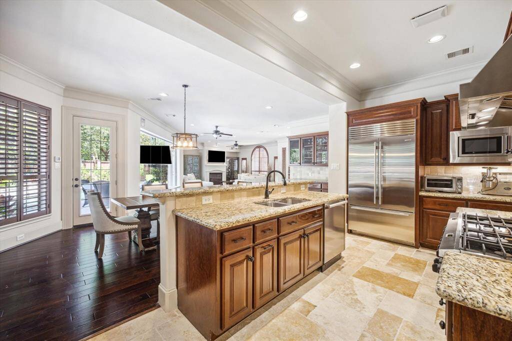 The kitchen seamlessly integrates with the dining and living spaces, creating an open and inviting feel. Notice the beautiful travertine flooring in the kitchen and utility room!