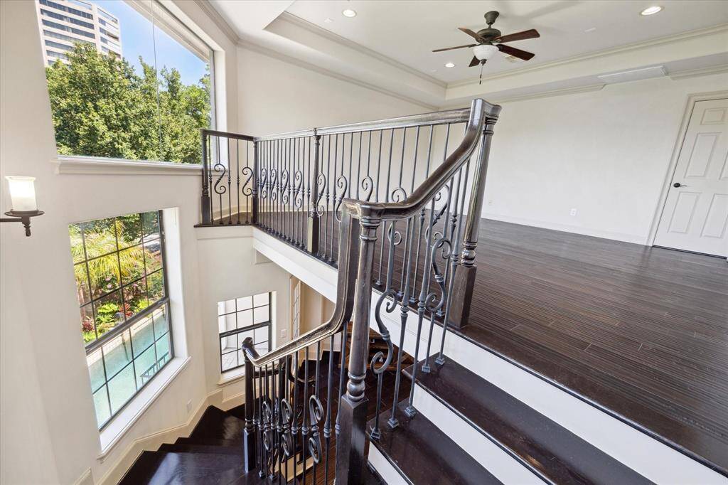 The stairs in the back leading from the den to the gameroom are framed with stunning windows that fill the whole area in natural light.