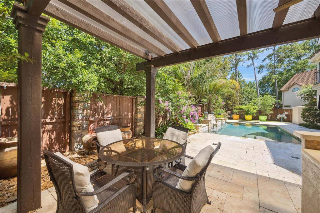 The outdoor covered kitchen space is further enhanced by an additional area for seating or dining.