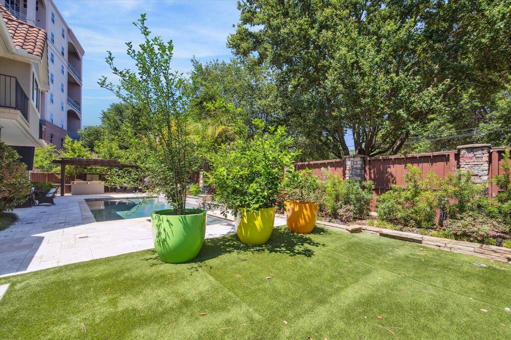 The backyard is enveloped by stunning landscaping, and the turf optimizes the green space, along with the stained fence.