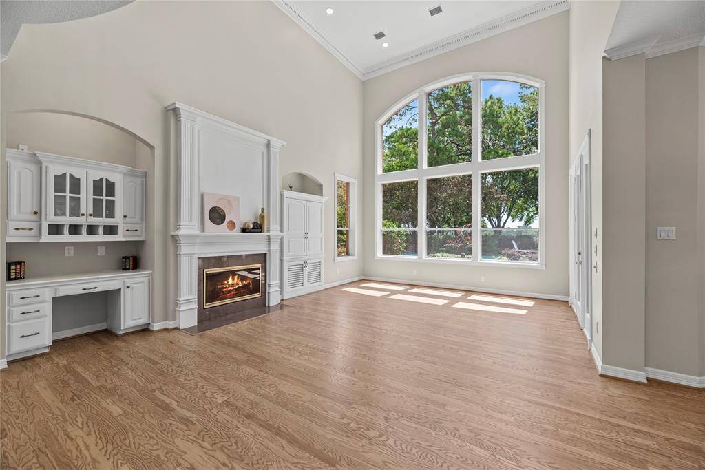 Elevated by a high ceiling, fireplace and custom built-ins, the family room beckons as a central gathering place with expansive views of the spacious grounds.