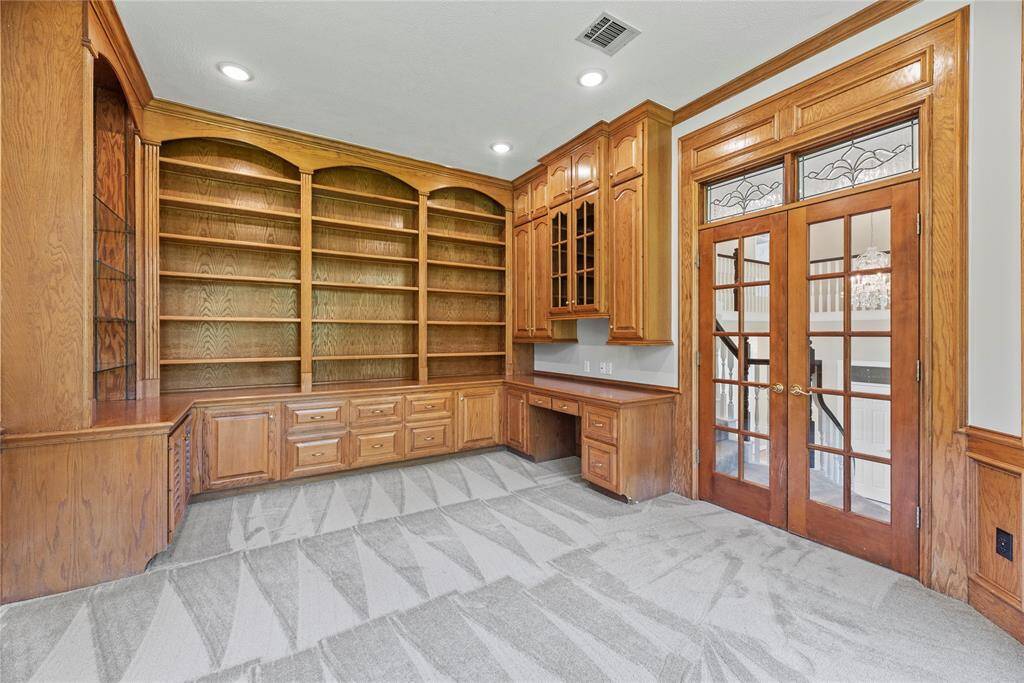 Halfway up the main staircase sits the handsome study with stunning custom built-ins.