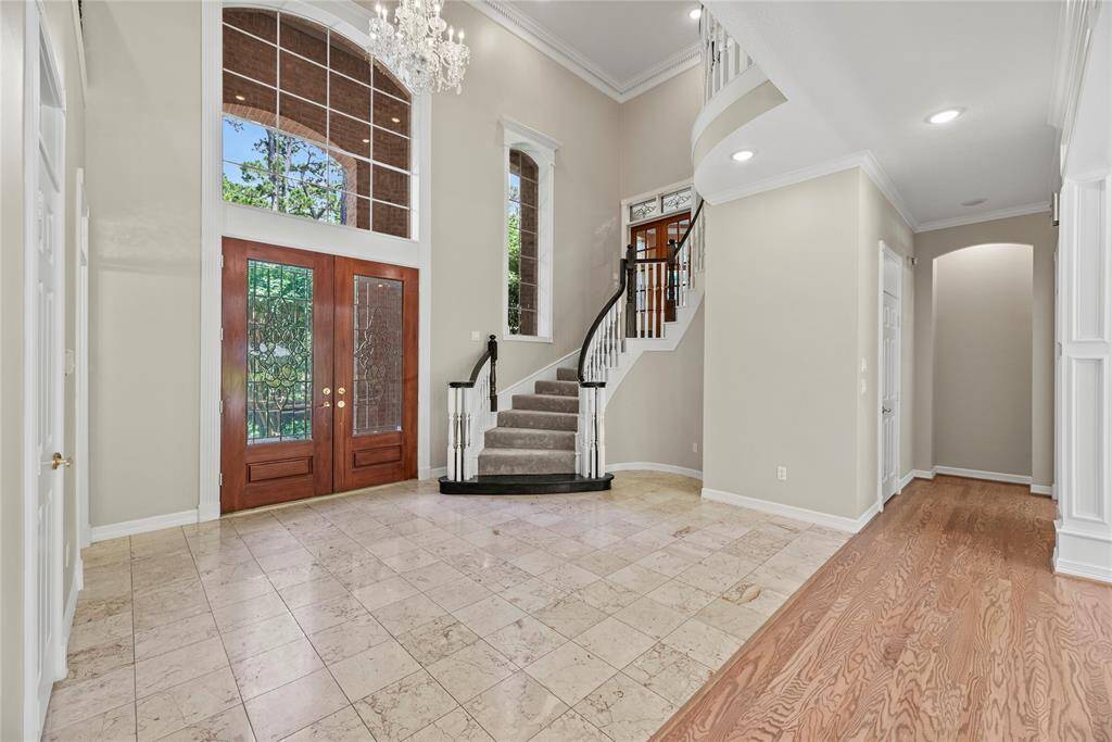 Step into luxury as the grand entrance welcomes you with gorgeous marble flooring and an exquisite chandelier complemented by neutral walls that exude sophistication. The high ceilings add an airy, expansive feel, setting the tone for an elegant atmosphere throughout.