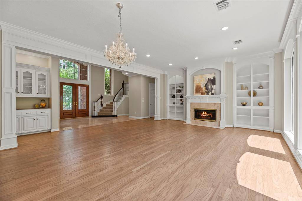 Just off the entry is the formal living and dining room with beautiful hardwood flooring, and a cozy fireplace surrounded by custom built-ins.