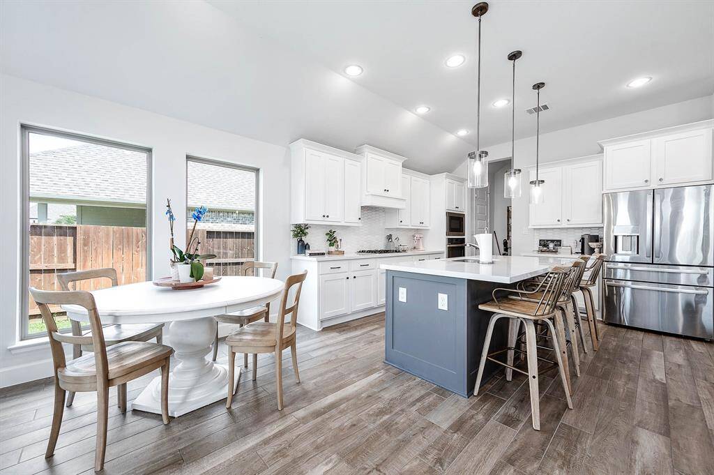 The kitchen boasts a breakfast bar that comfortably seats four barstools, along with an adjacent dining area. This setup is perfect for casual meals and offers additional space for dining and socializing.