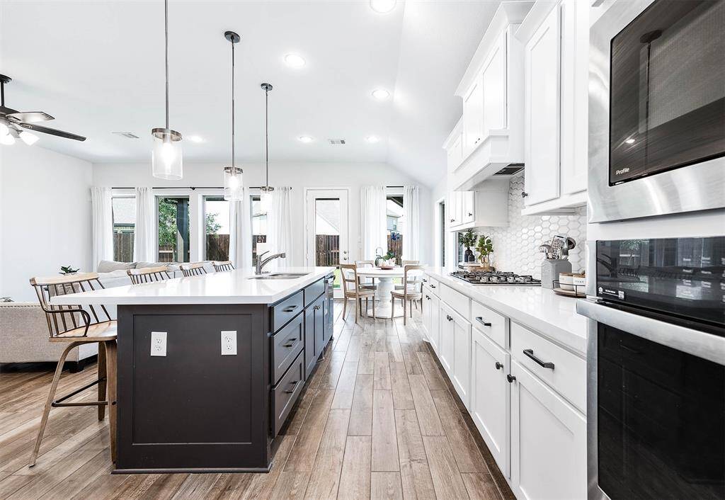 The beautiful kitchen offers ample counter and cabinet space, with the island featuring the kitchen sink. This setup provides convenience and functionality, making meal preparation and cleanup a breeze.