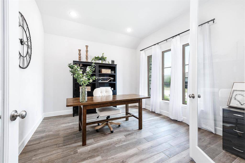 Solid glass double doors and windows overlooking the front yard make for the perfect office space!