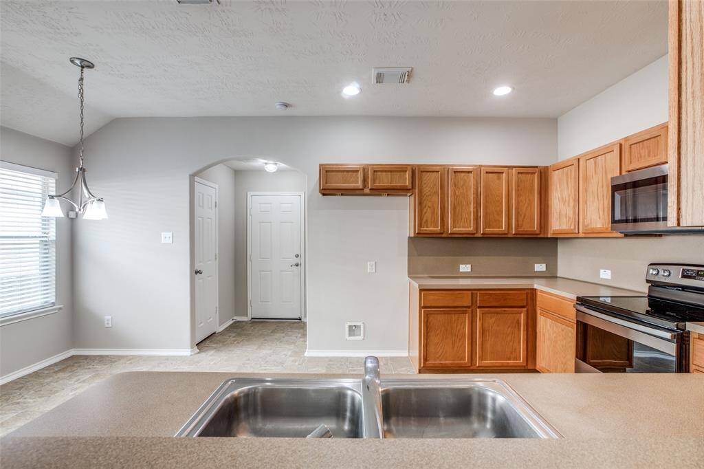 View of kitchens shows the back door leading to the covered back patio and door to the left is a large walk in pantry.