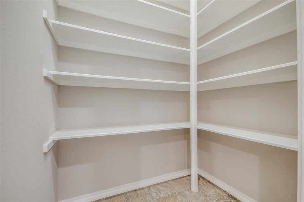 Large walk in pantry with lots of shelving.