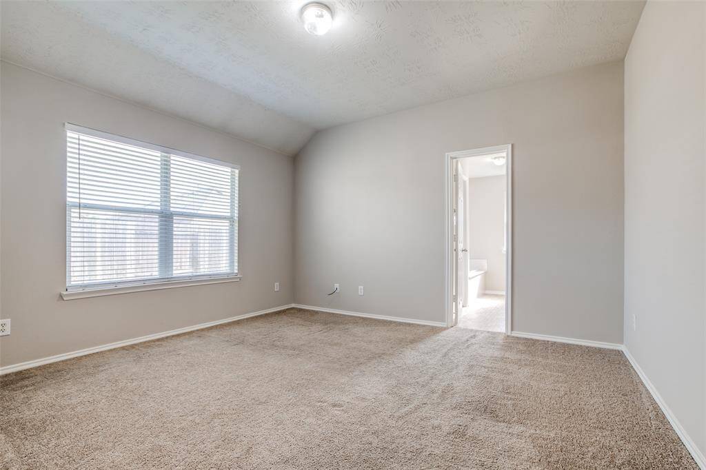 Primary bedroom at the back of the home. You can see door leading to the primary bath.