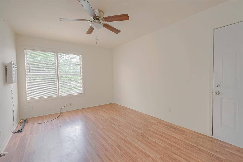 The bedroom features wide windows and a ceiling fan perfect for those hot summer days.