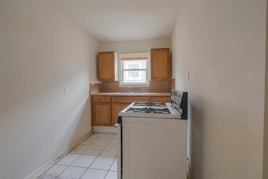 Small kitchen featuring a gas stove and ample storage space.