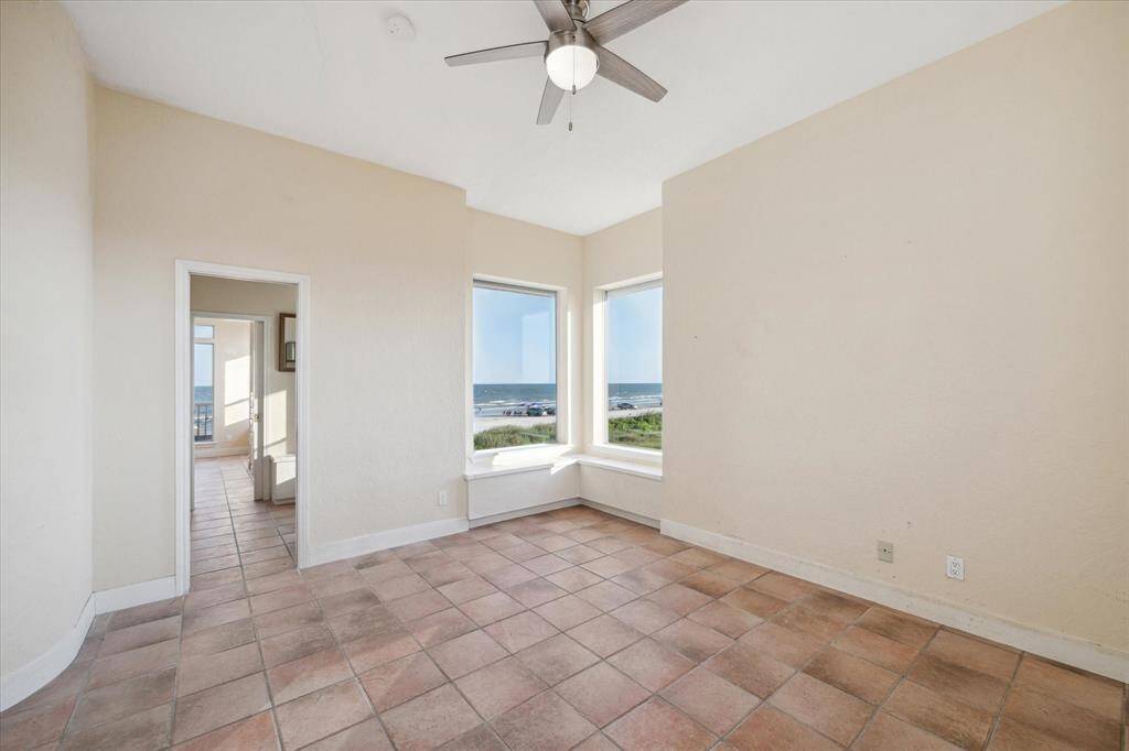 The front bedroom has large windows with ocean views and a doorway leading to a shared bathroom.