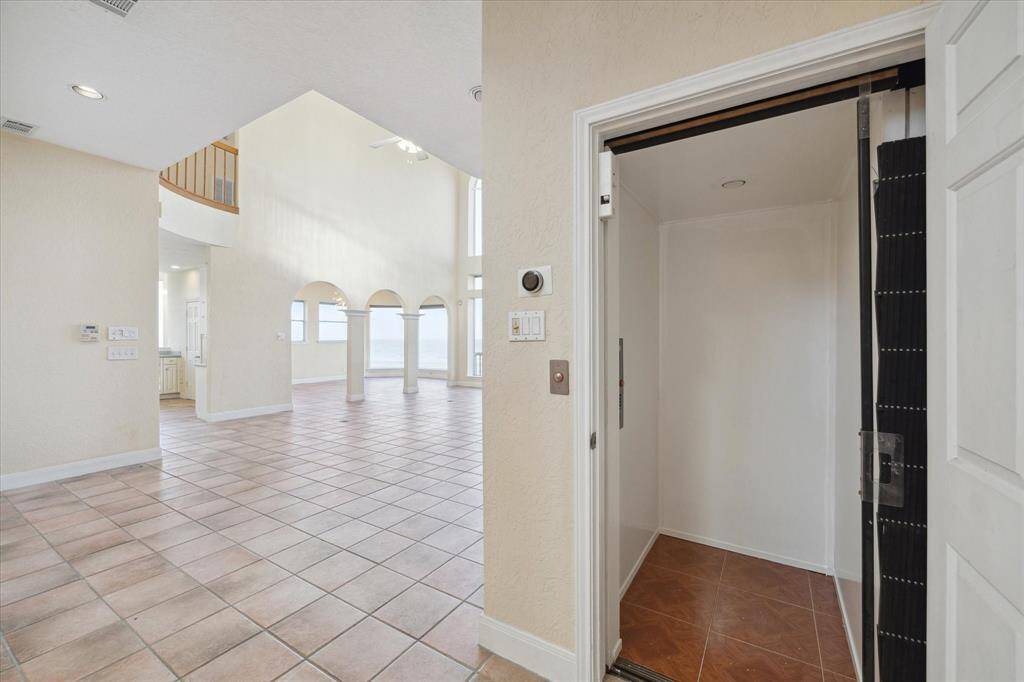 Residential interior with high ceilings, arched doorways, and an elevator that goes to all levels.