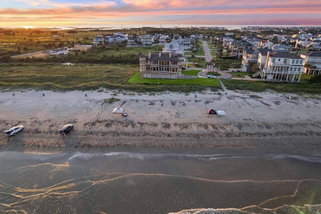 Aerial view of a beachfront with houses during sunset.