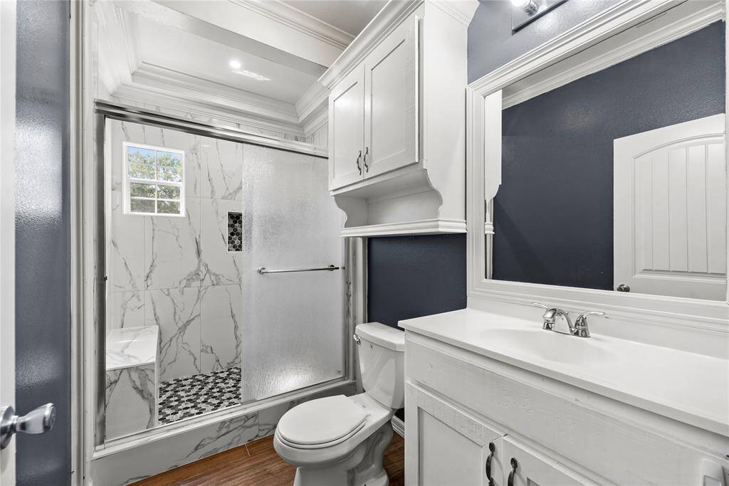 Updated with a designer feel this is your primary bath with oversized walk-in shower with sitting bench.