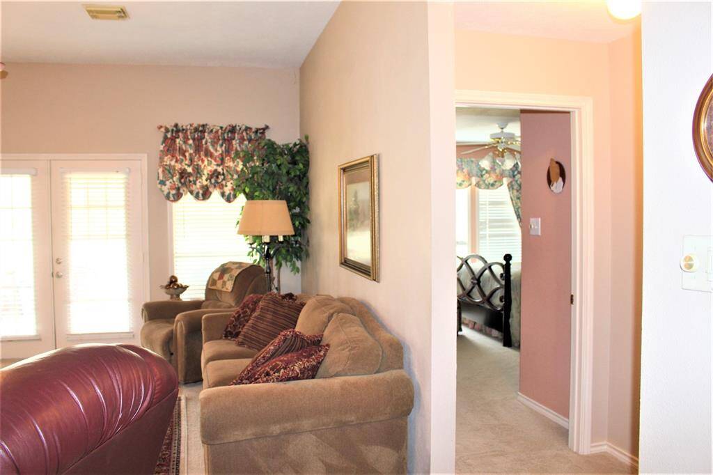 View from entry way looking into living room and showing Primary bedroom to right.