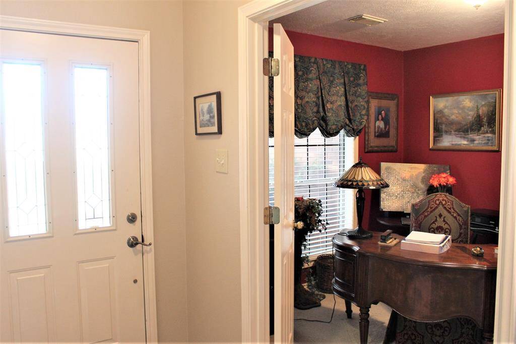 Front door, and then double doors open to this bedroom/office. Room is approx 11x 11  and has a nice size closet and double low windows overlooking the fron yard.