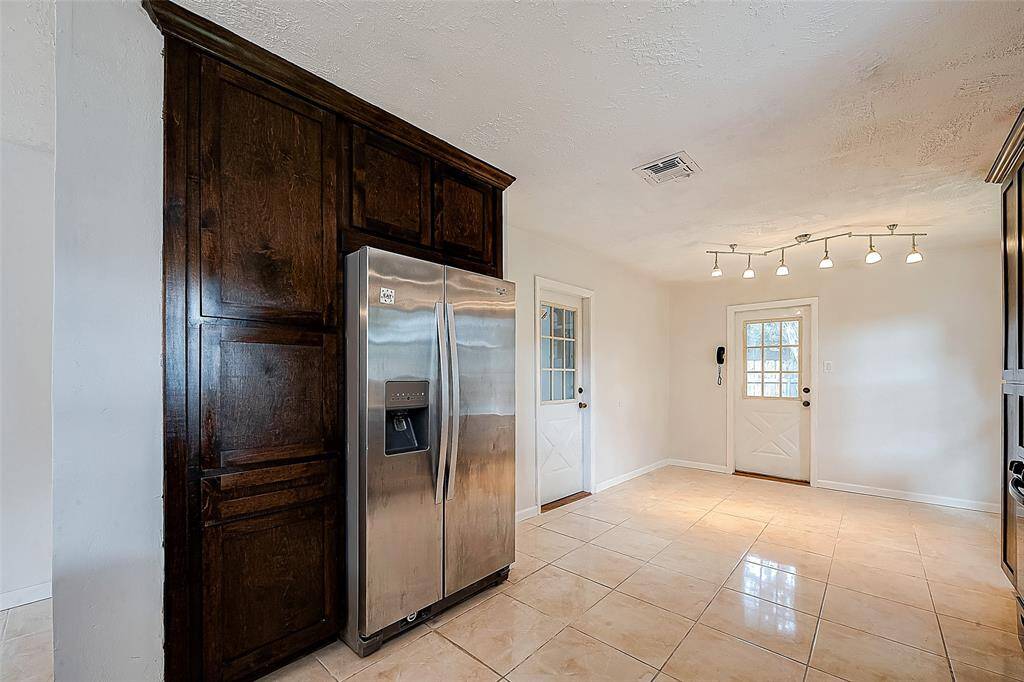 FULL STORAGE PANTRY BUILT-IN NEXT TO THE REFRIGERATOR. THERE IS A BREAKFAST NOOK UNDER THE LIGHTING BY THE SIDE DOOR.